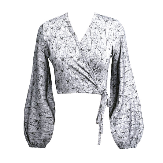 A white and black geometric wing print wrap top with blouson sleeves and a tied waist, displayed against a plain background.