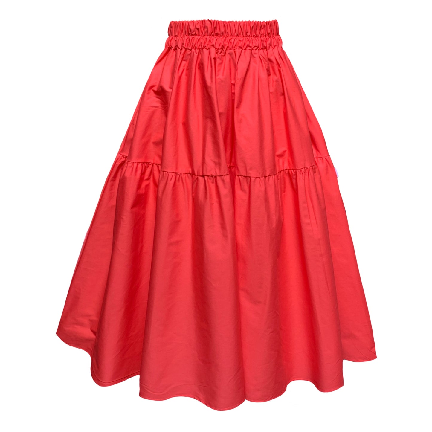 An orangey red midi skirt with pockets, made from cotton, with a wide elastic waistband and a full skirt silhouette.