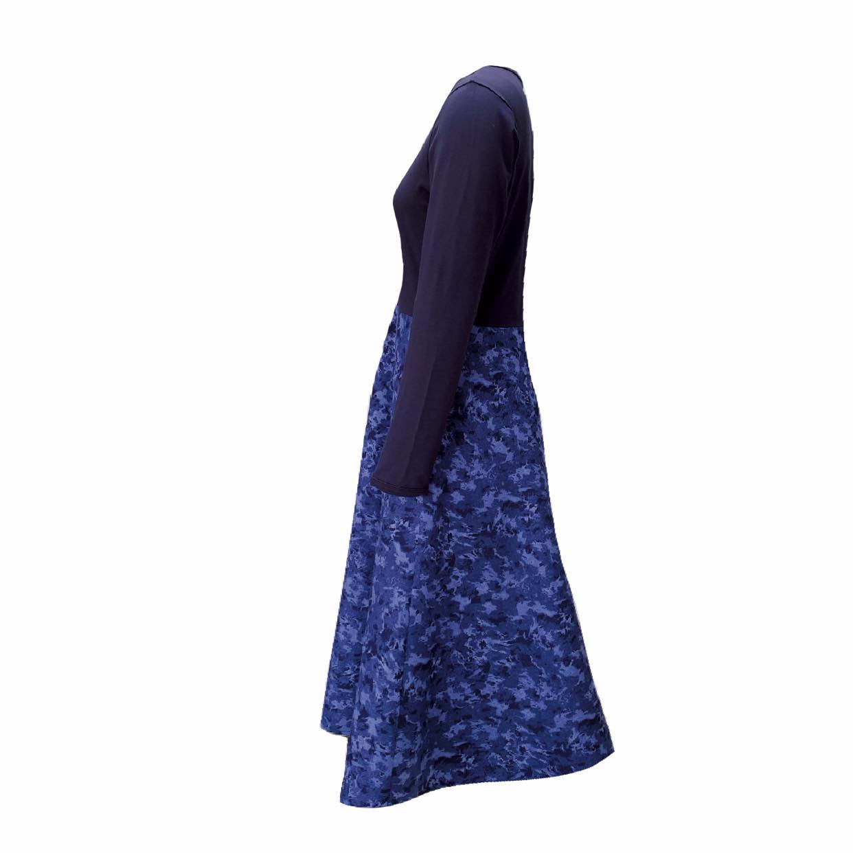 Pictured is the side of the Amiira Dress in Colbalt Waves. It is long sleeved navy top with a full patterned skirt