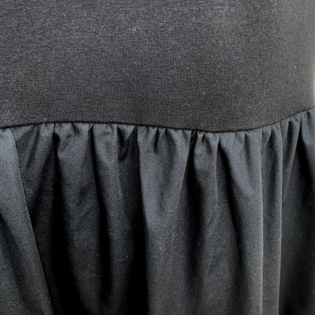 This is a closeup of a black dress, showing the detail of the gathered skirt.