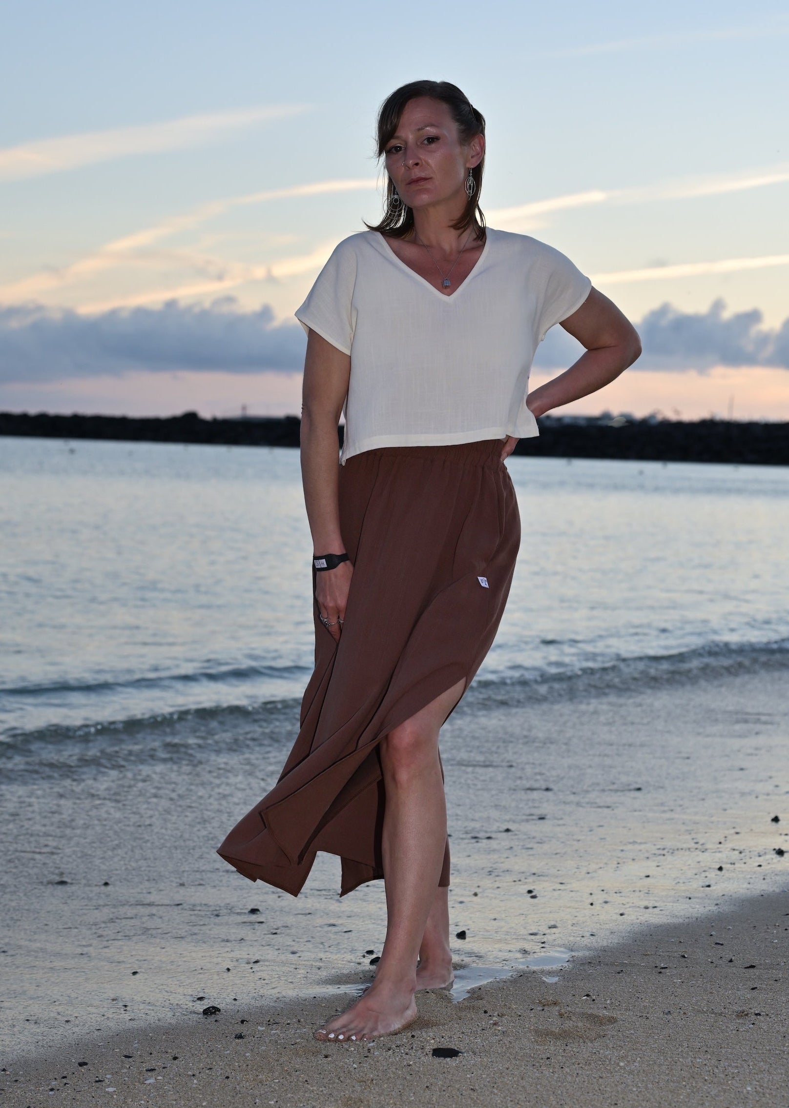 Woman standing on a beach with a sunset in the background