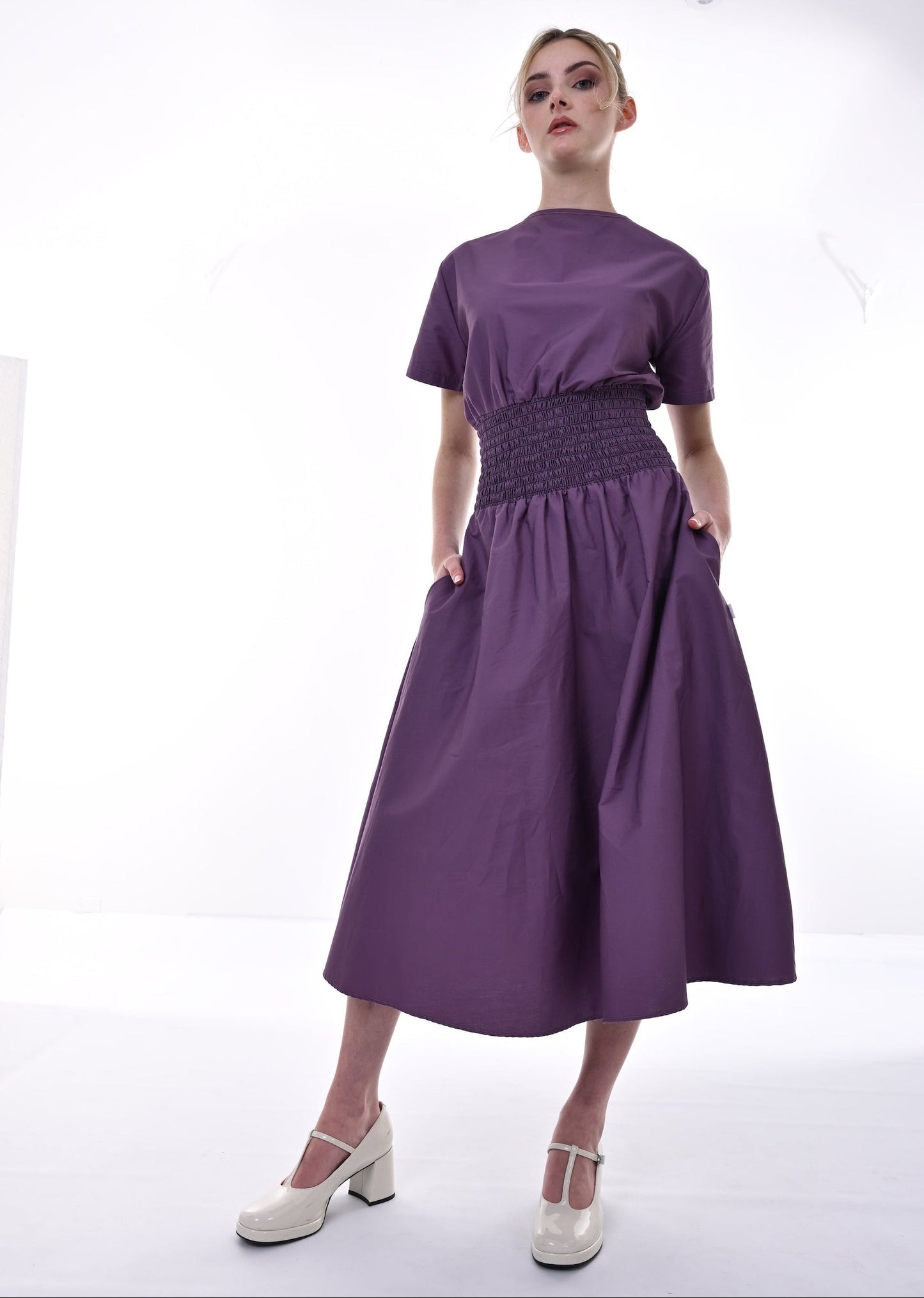 Woman wearing a purple dress with a white background