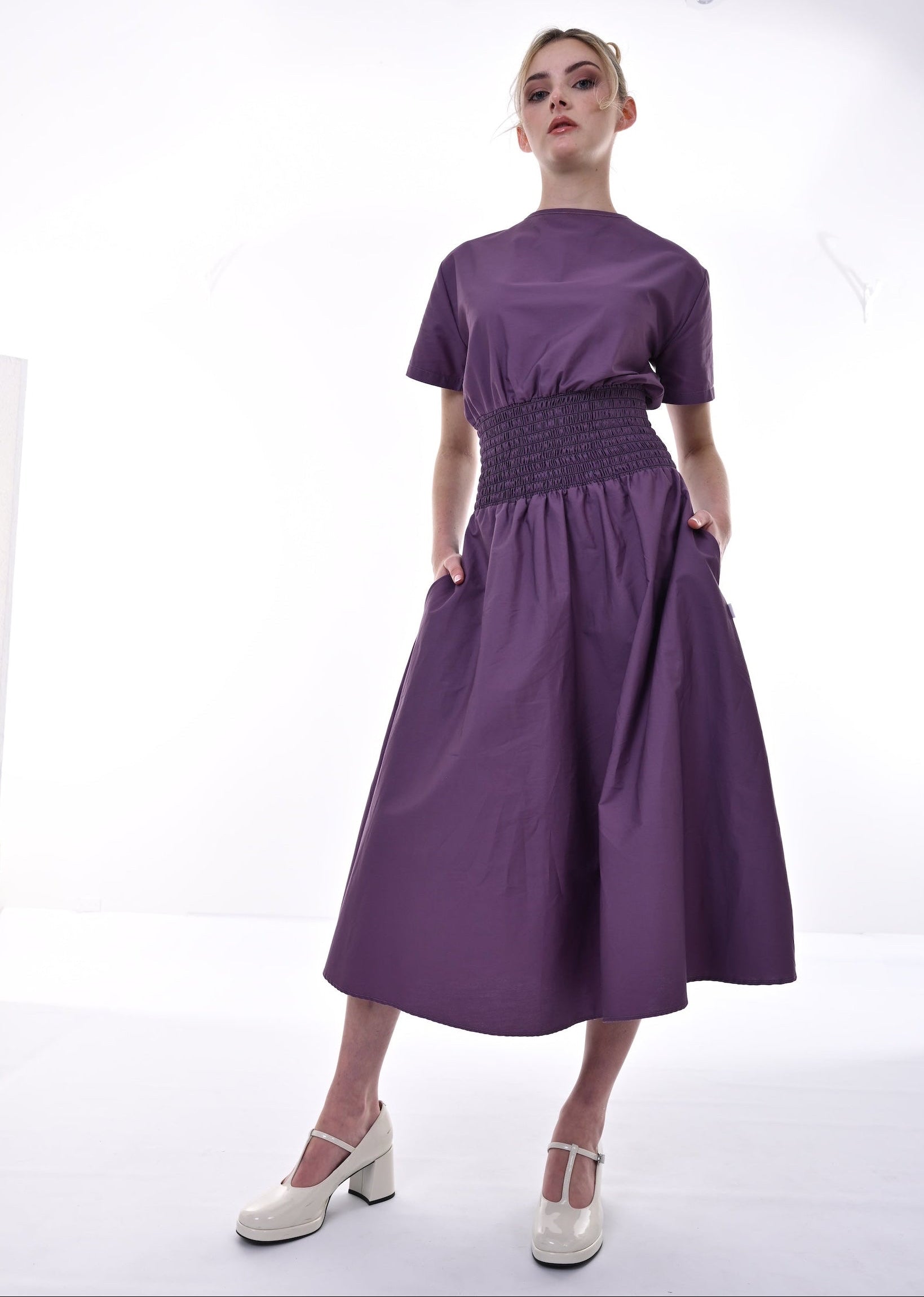 Woman wearing a purple dress with a white background