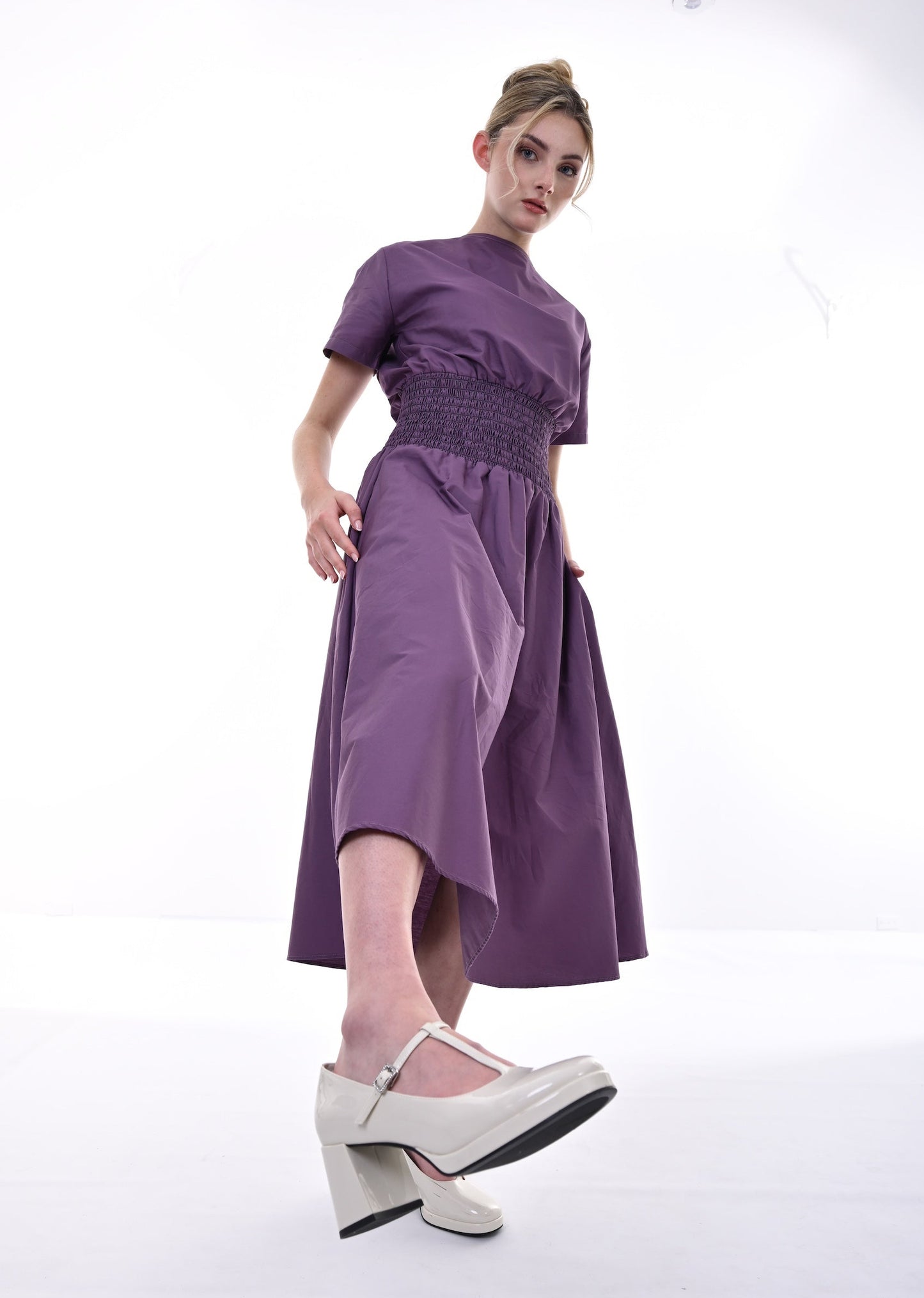 Woman wearing a purple dress with a white background