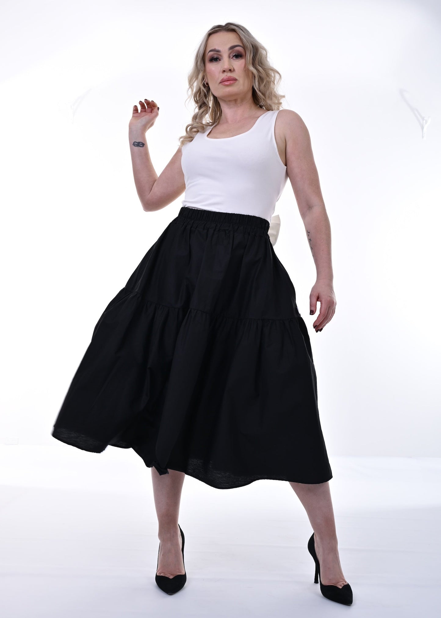 Woman wearing a white top and black skirt on a white background