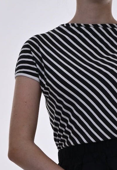 Woman wearing a black and white striped top with a black and red skirt on a white background