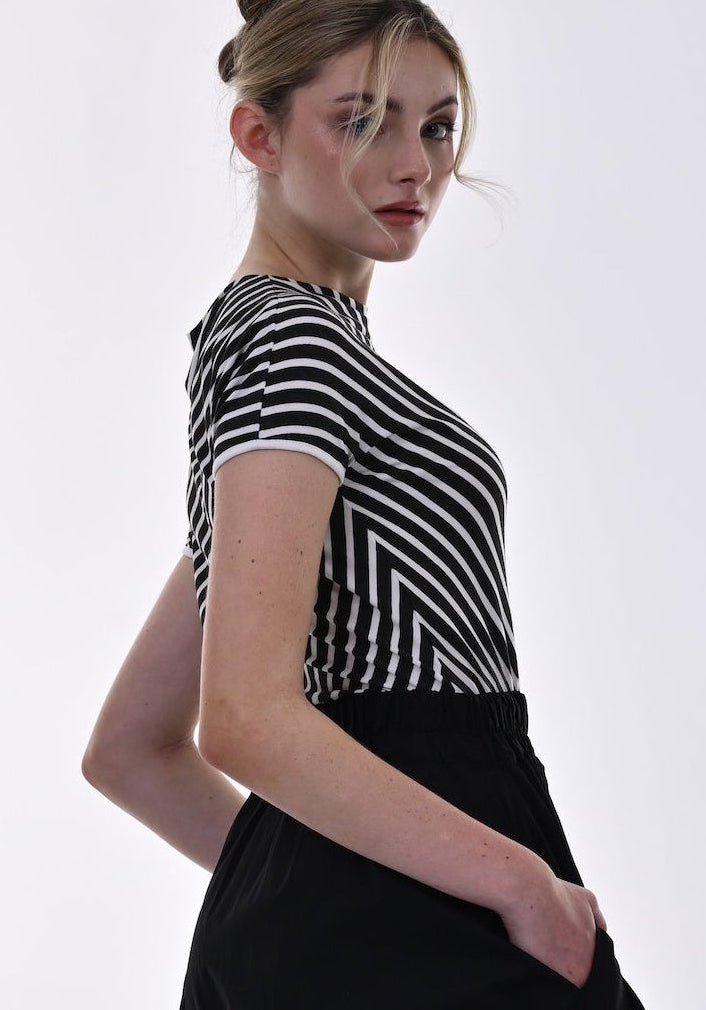 Woman wearing a black dress and striped top on a white background