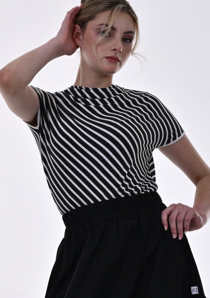 Woman wearing a black and white striped shirt and black skirt on a white background