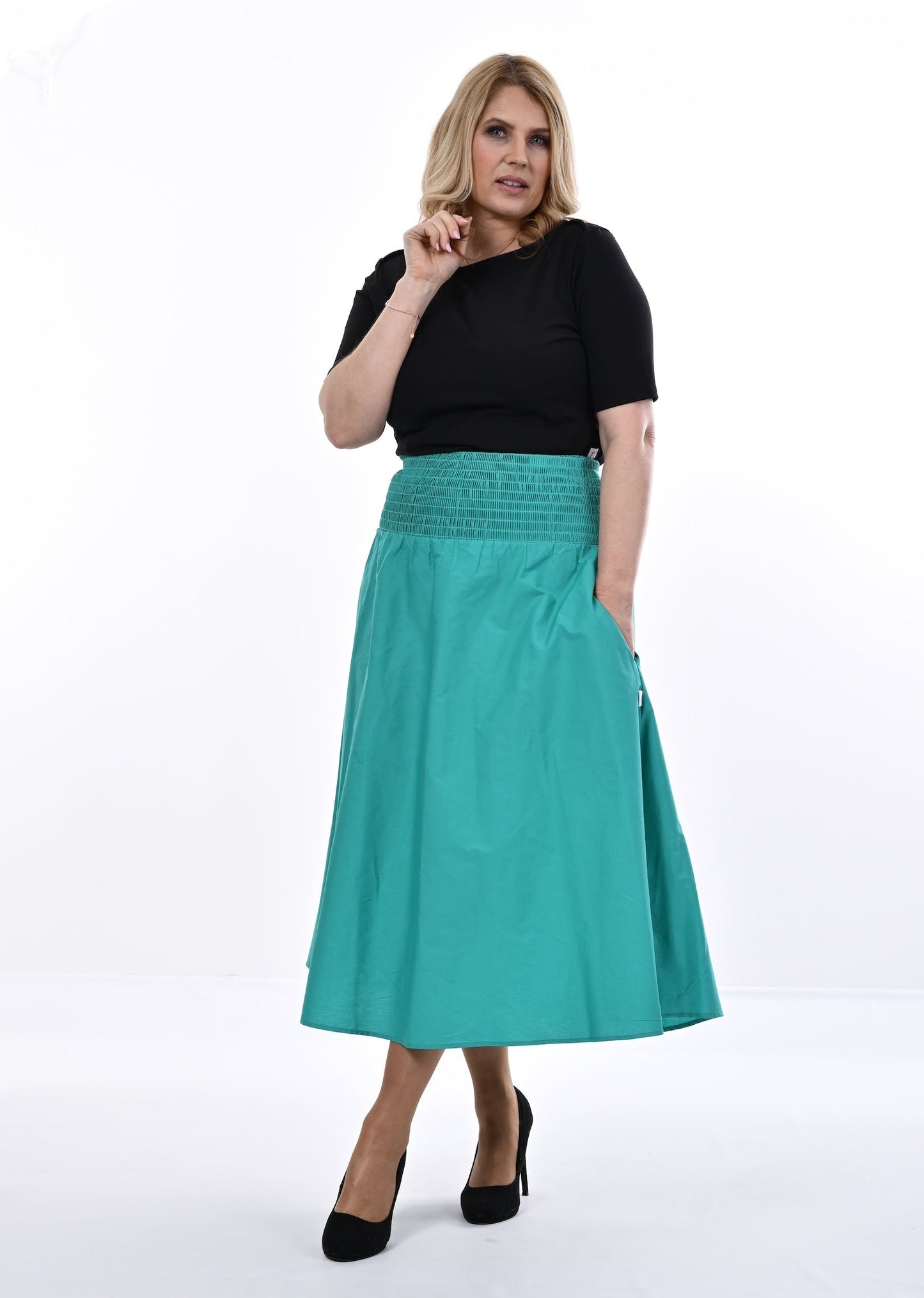 Woman wearing a black top and an Aqua skirt on a white background