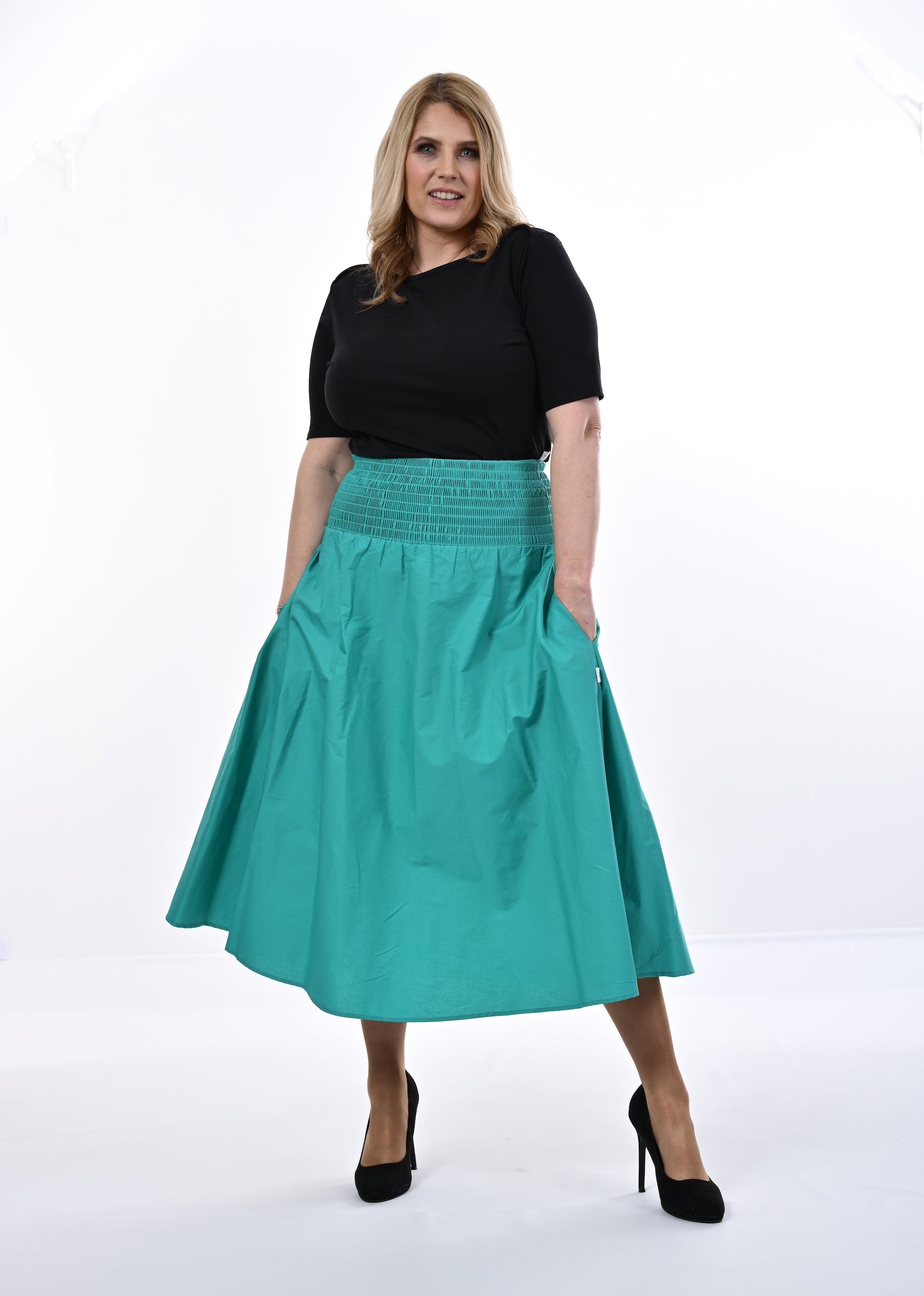 Woman wearing a black top and an Aqua skirt on a white background