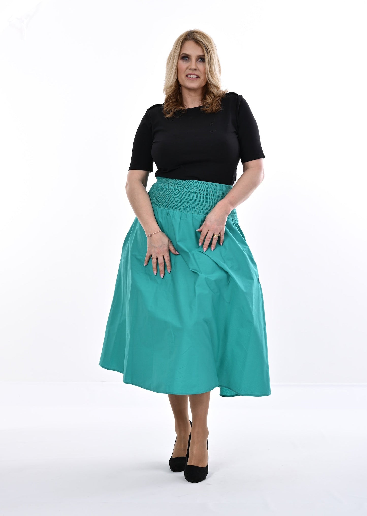 Woman wearing a black top and an Aqua skirt on a white background