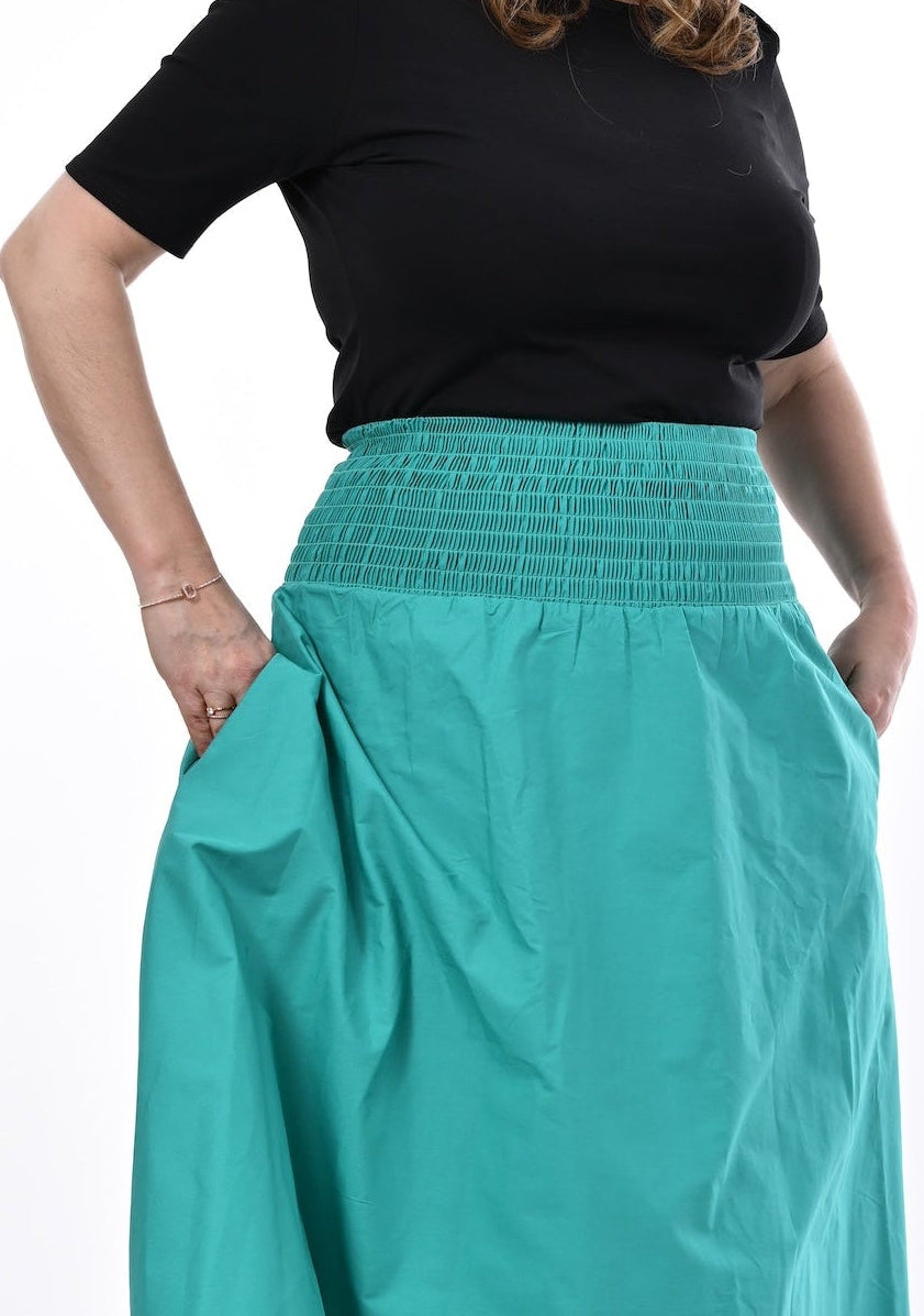 Woman wearing a black top and an Aqua skirt on a white background