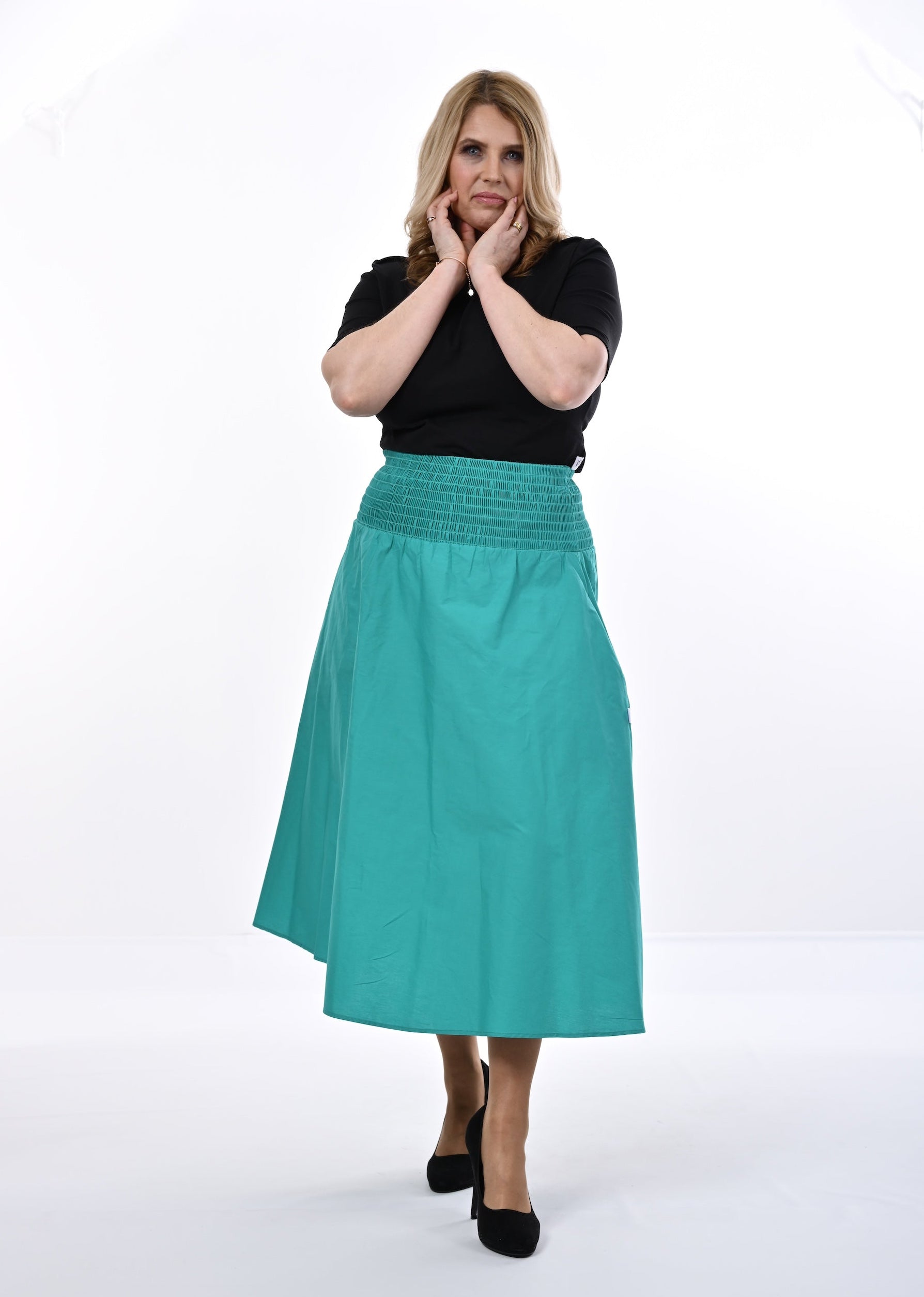 Woman wearing a black top and an Aqua skirt on a white background
