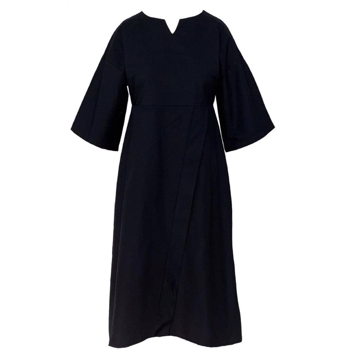 This is a black dress silhouetted against a white background. It is a midi length and has a scoop neck with a notch in the centre front. The 3/4 sleeves are loose with a wide cuff. The dress is pull-on but has shape and is semi fitted. The skirt is A Line with a non functional wrap that shows just the right amount of leg. 