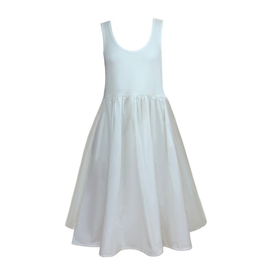 This is a picture of a sleeveless dress in cream set against a white background. The low scoop neck is bound with self fabric. The skirt os gathered on the the top and has a loose flared look. The side seam pockets are hidden. The top of the dress is in jersey and the skirt is in woven supima organic cotton.